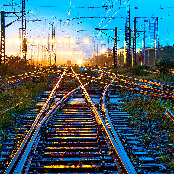 A train track with clouds and blue sky in the distance