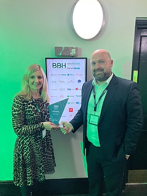 Head of marketing and head of healthcare sales shaking hands as they receive the award 