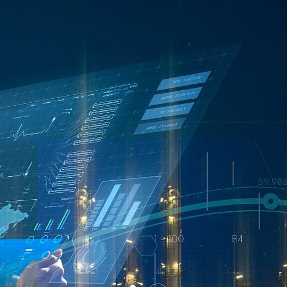 Image of a man stood in front of a visualisation with an industrial background.