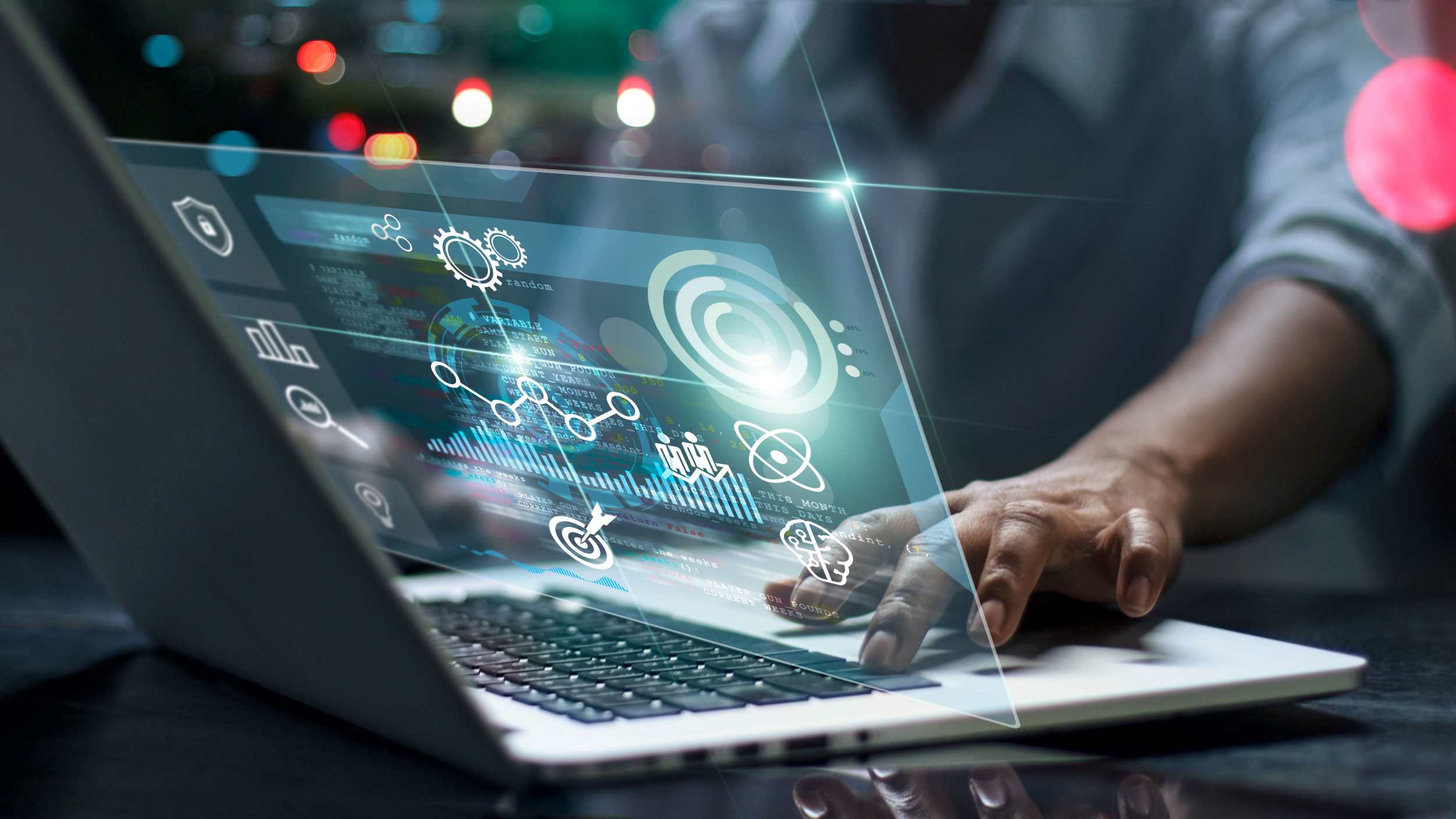 A person on the computer with a visualisation on the screen with various different icons.