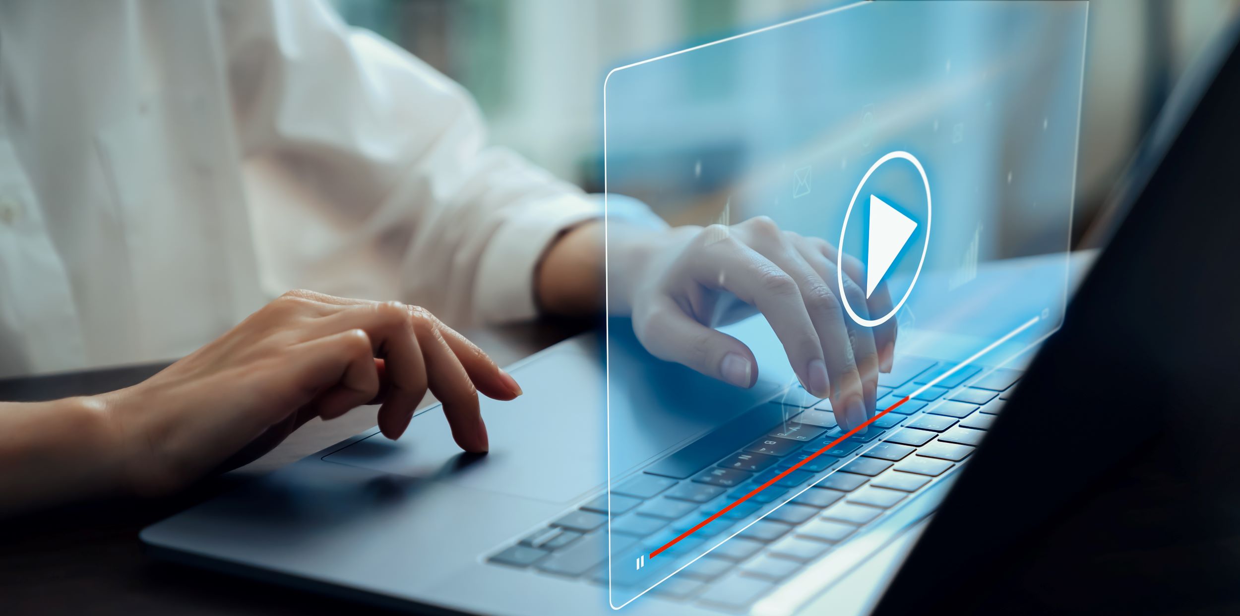 A person on a laptop with a video visualisation coming out of the laptop screen to play a video.