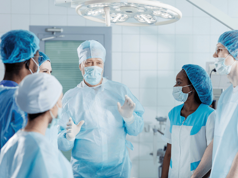 Image of surgeon sharing information with surgical team in an operating theatre