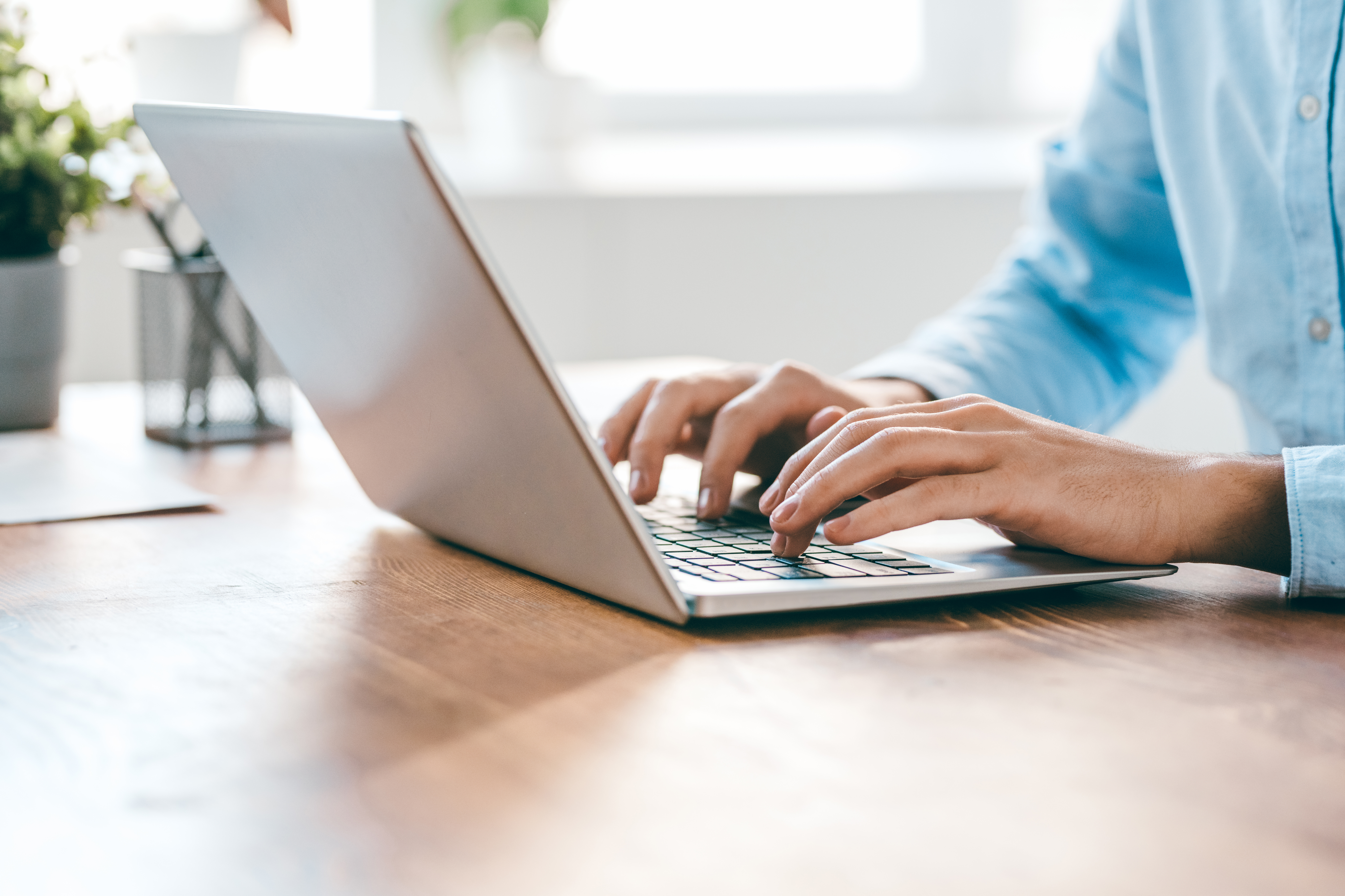 A person typing on a computer at a desk