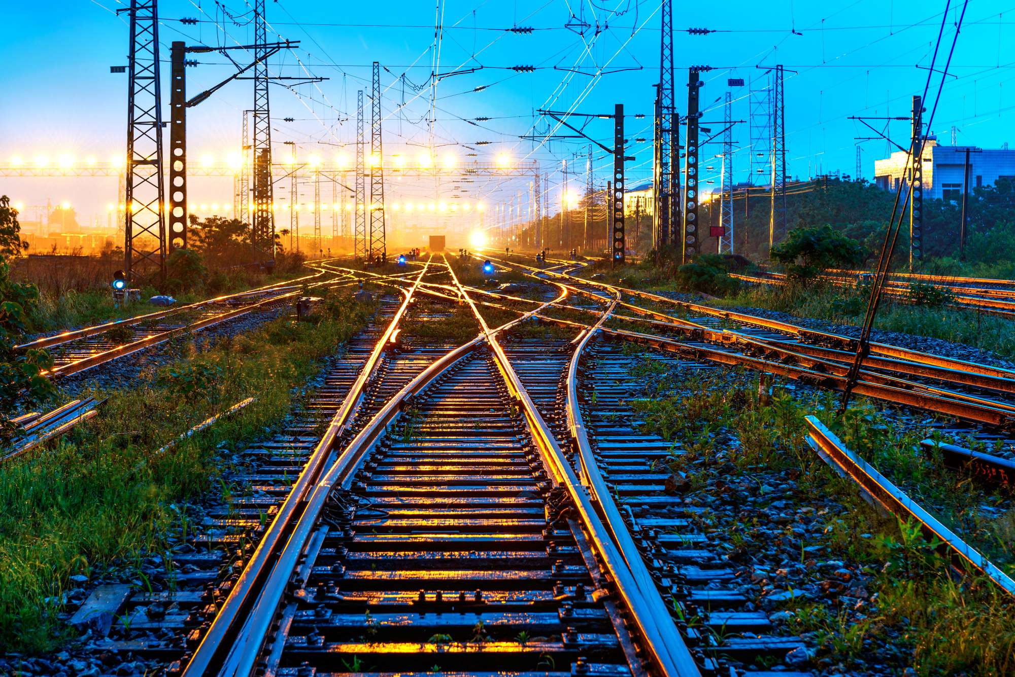Image of railway lines with lights and track fading into the distance
