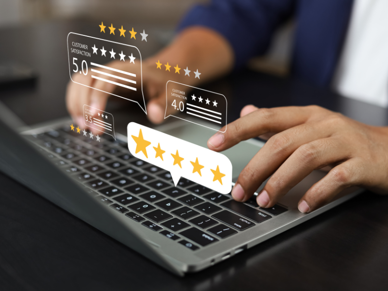 Individual sat at a computer typing with a review visualisation in front of the screen