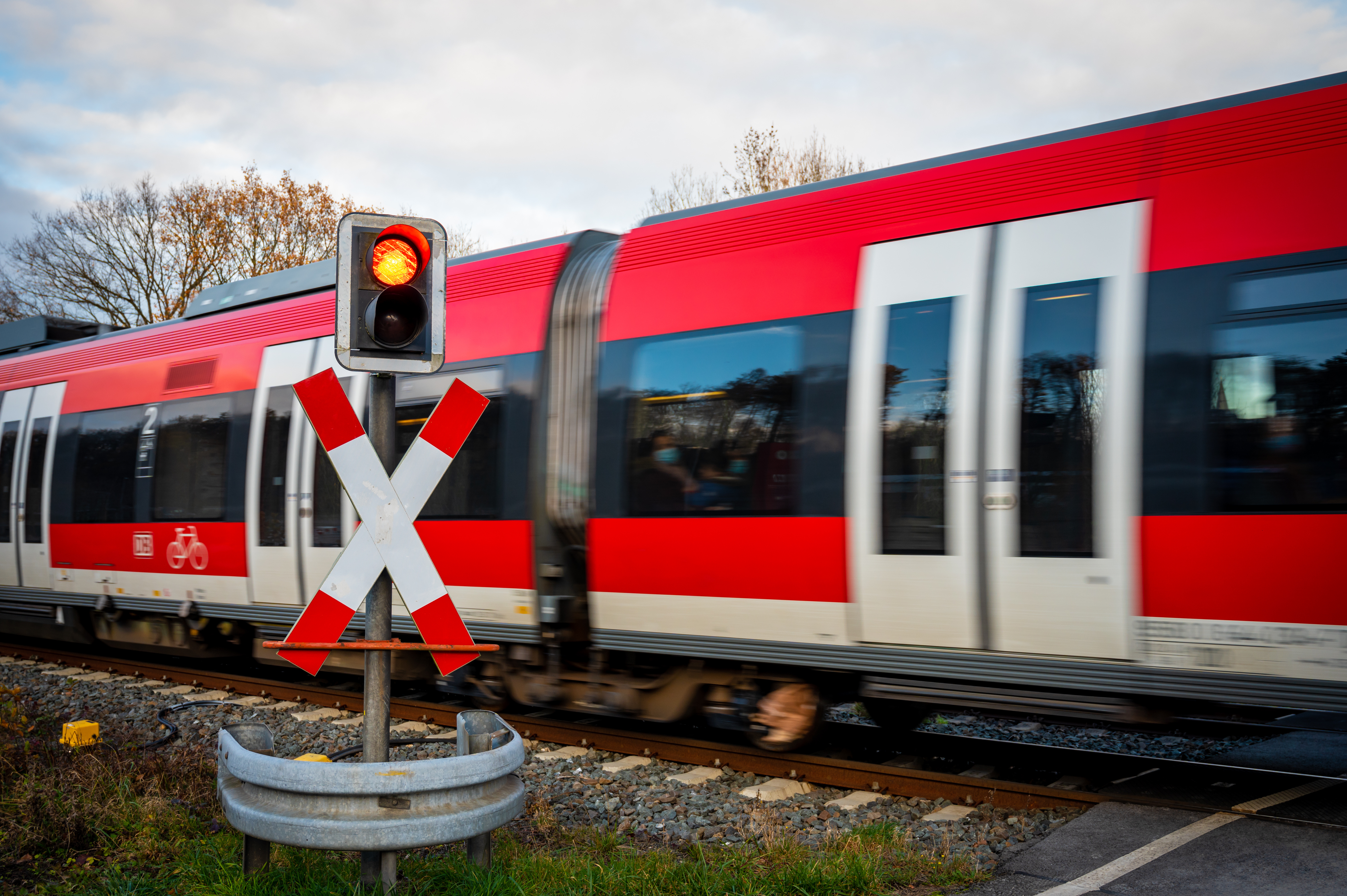 An image of a train passing through a railway crossing.