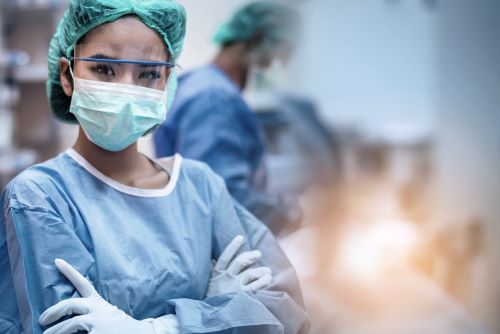Surgeon in operating theatre with other surgeons performing an operating