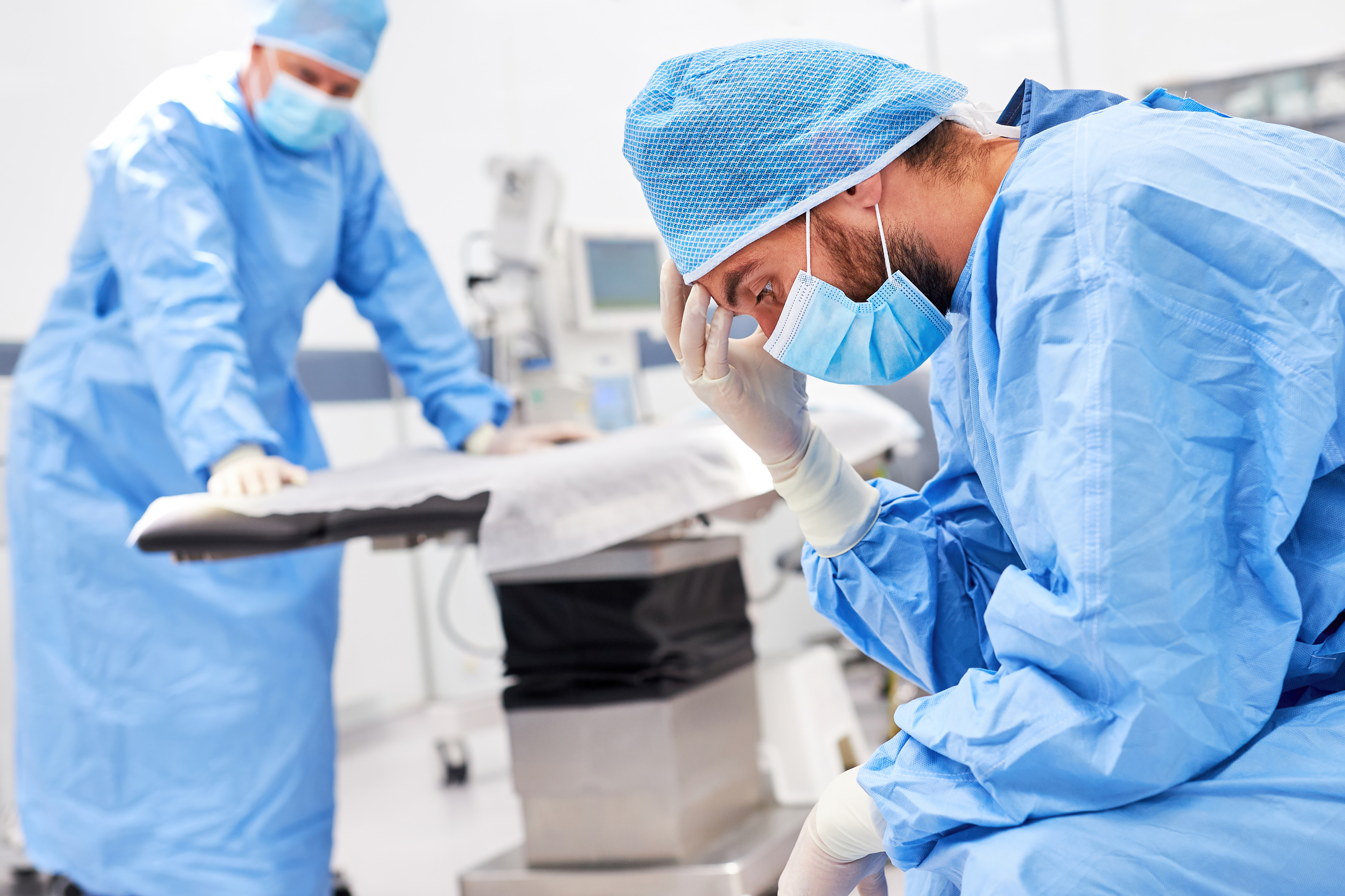 Surgeon with hands on his head looking stressed